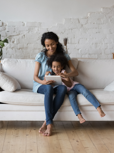 A mother and daughter sit on their couch and plan for their eco-friendly home renovation