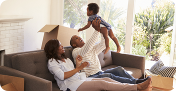 New parents playing with their baby inside their new home.