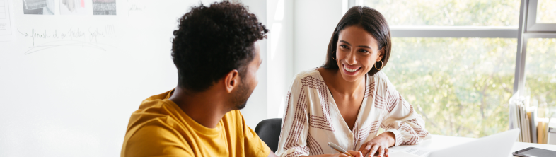 A couple sit in their office and checks their credit scores on their laptop to plan towards their financial future